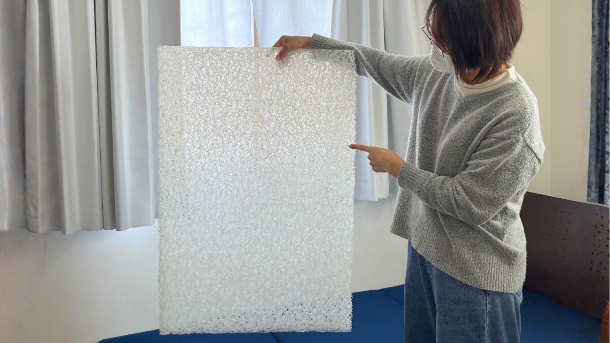 3分割されたネムリエマットレスの中芯を、女性が片手で軽々と持ち上げている様子。